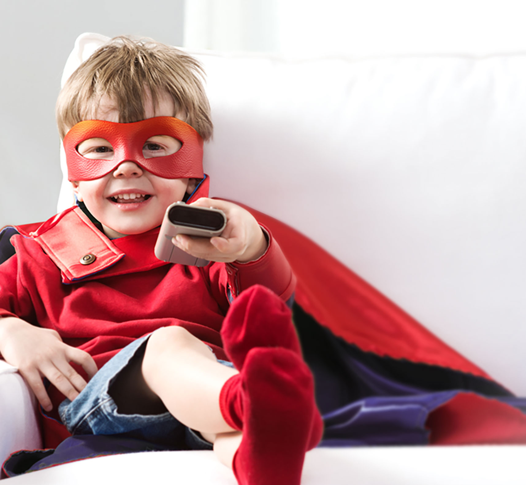 Kid in costume on couch with remote